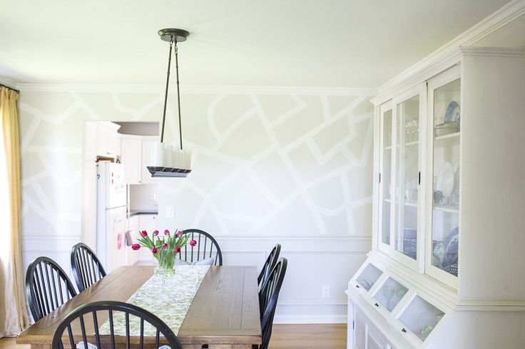 A dining room with white walls and wooden table.