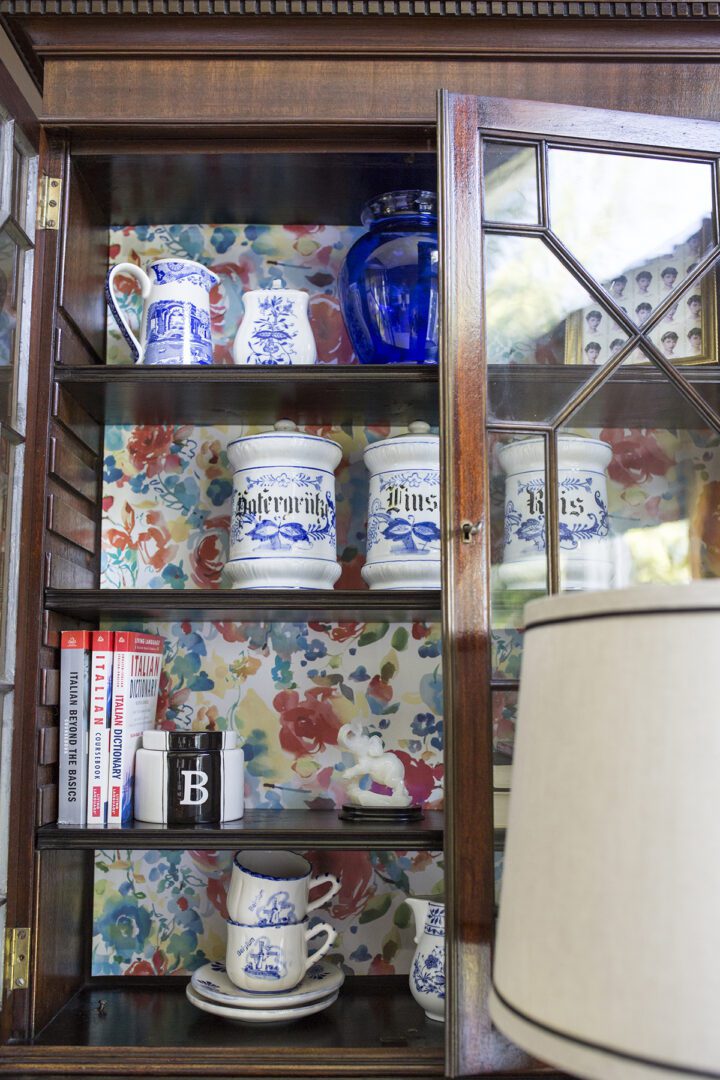 A bookshelf with some blue and white jars on it