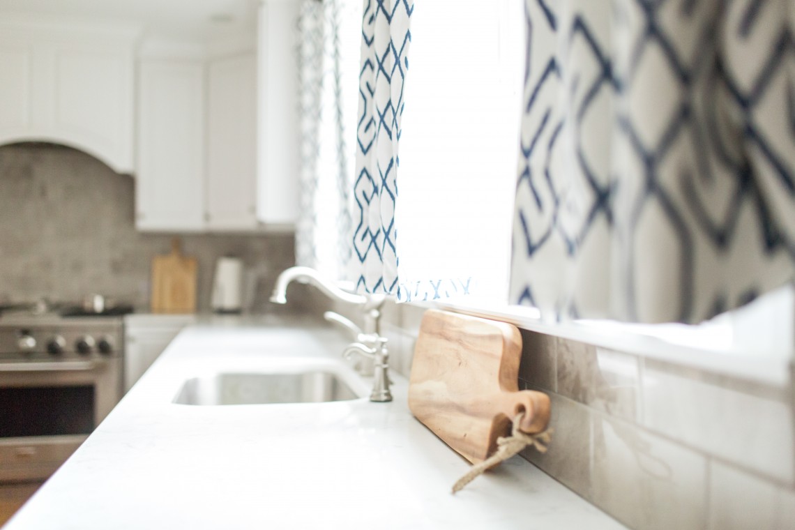 A kitchen counter with a cutting board and sink.