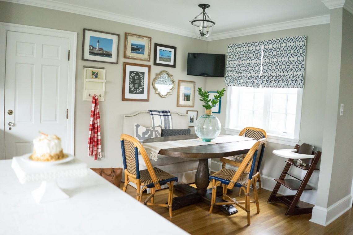 A dining room with a table and chairs, and pictures on the wall.