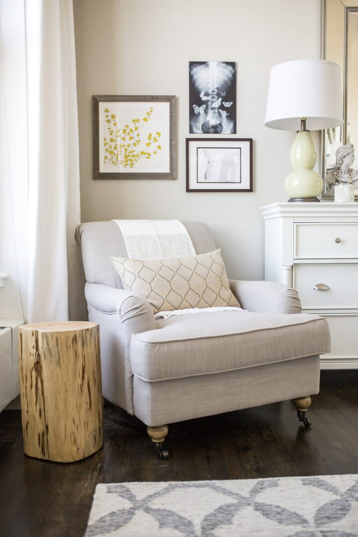 A living room with white furniture and a tree stump.