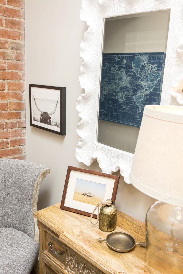 A living room with a lamp and pictures on the wall