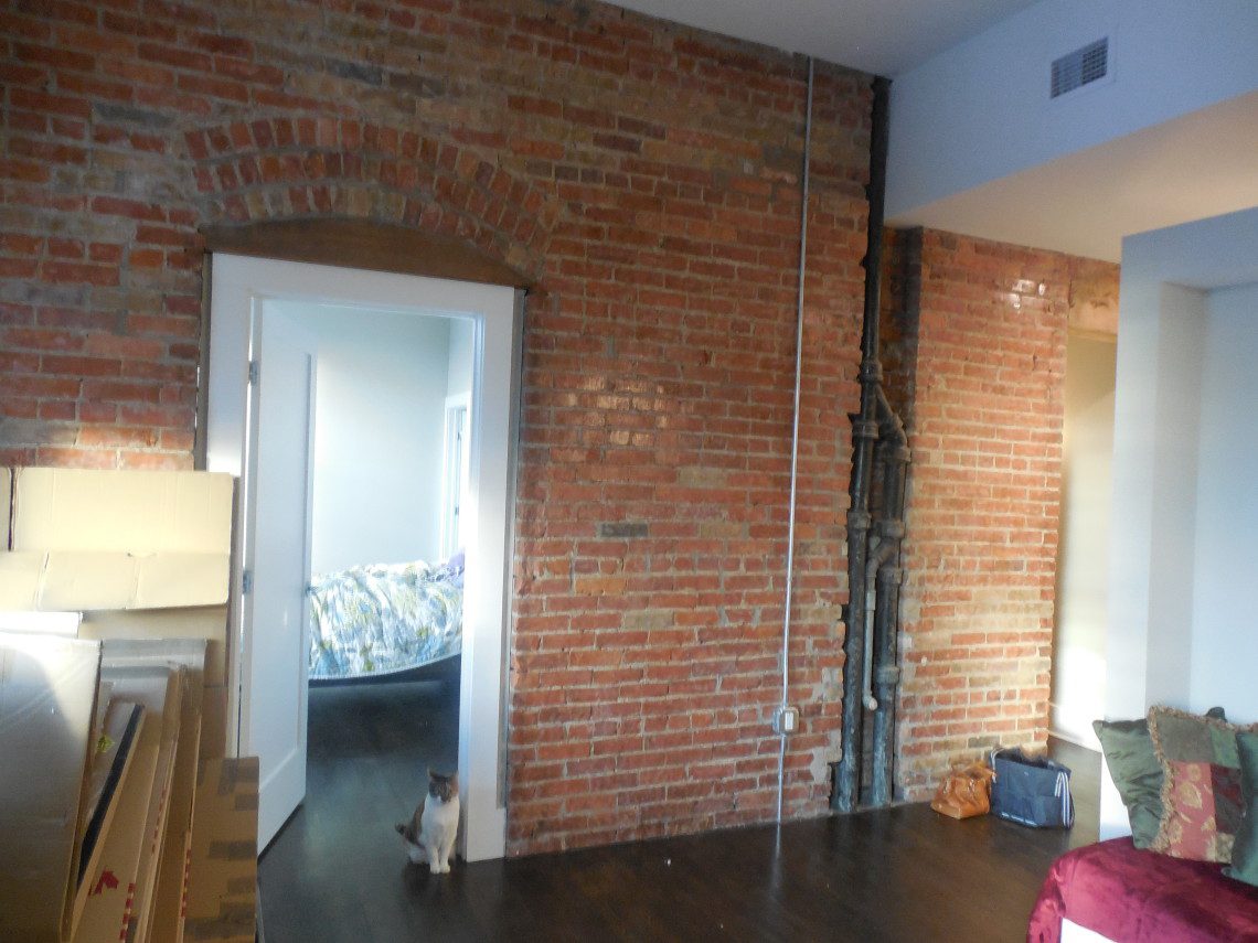 A room with exposed brick and wood floors.