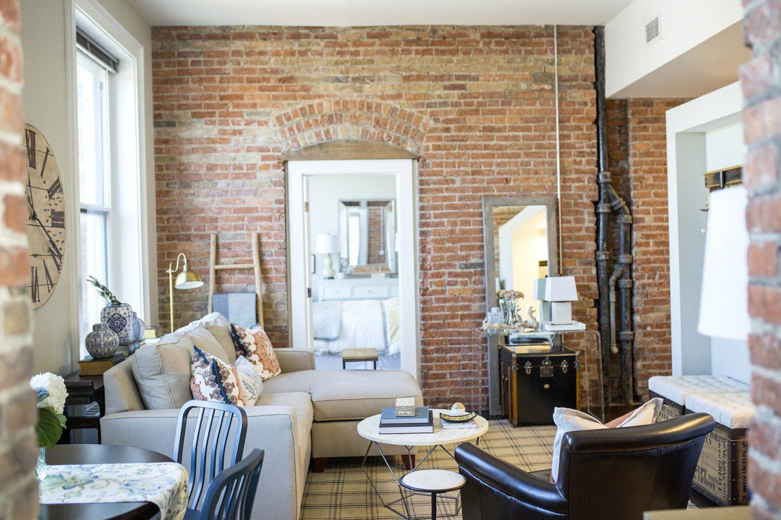 A living room with brick walls and a white couch