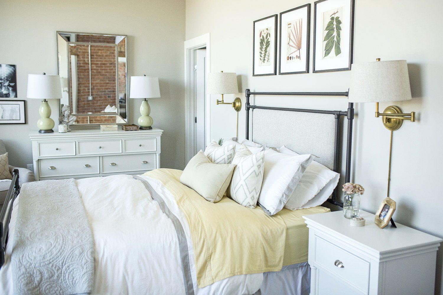 A bedroom with white walls and a yellow comforter.