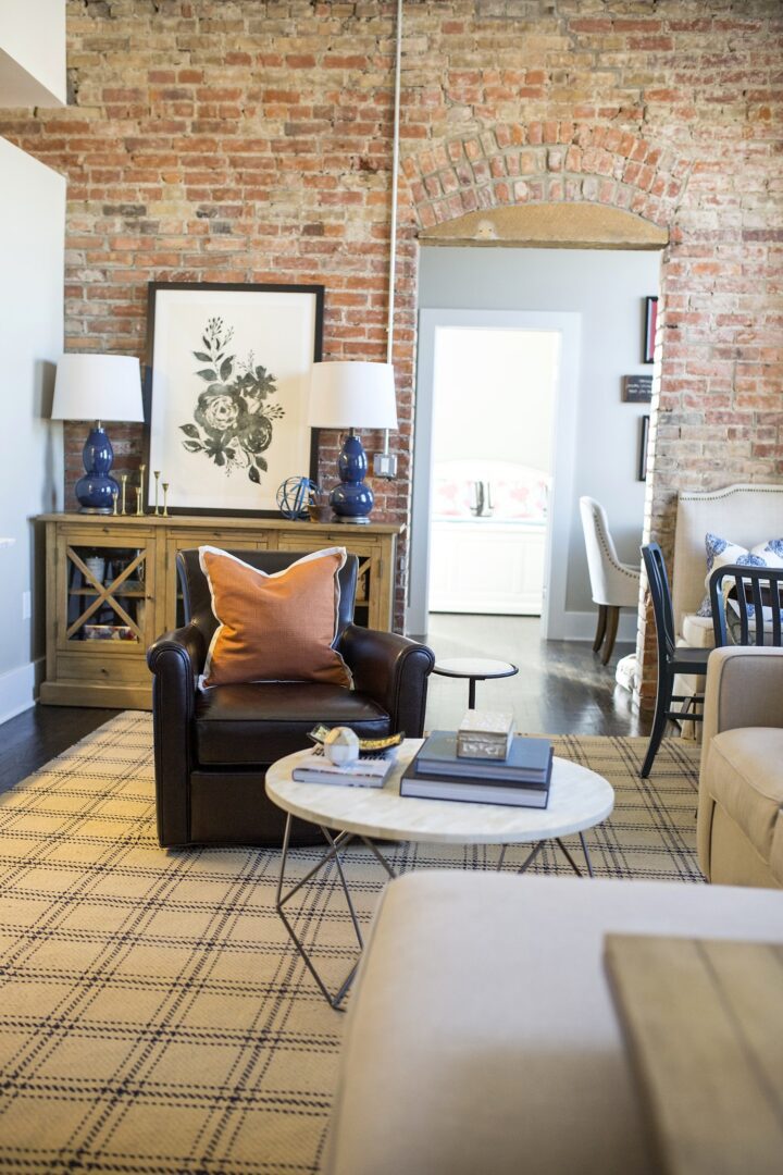 A living room with brick walls and a leather chair.