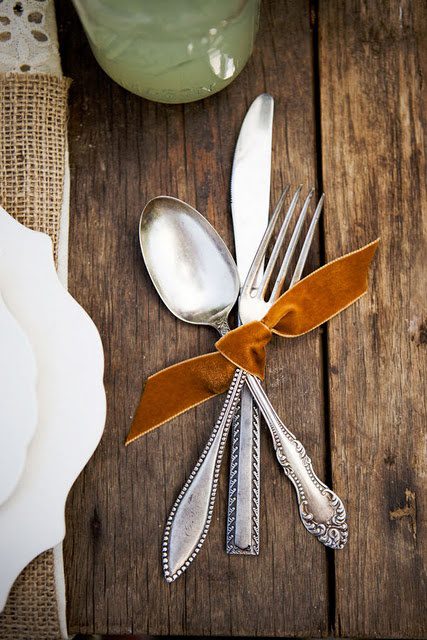 A table set with silverware and napkin tied to each other.