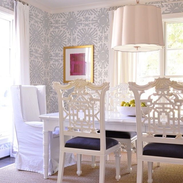 A dining room with white chairs and a table