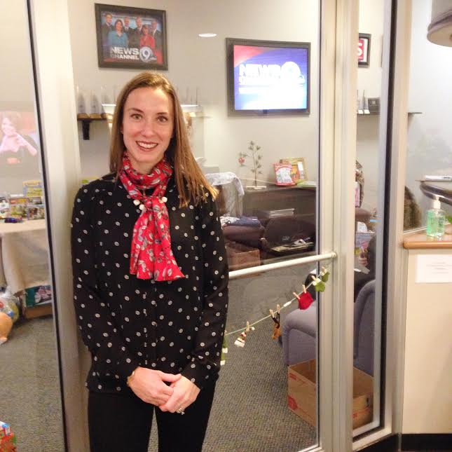 A woman standing in front of a glass door.