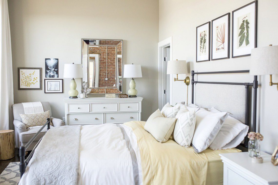 A bedroom with white furniture and yellow sheets.