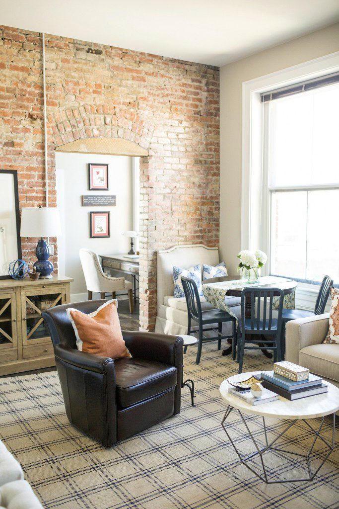 A living room with brick walls and a table