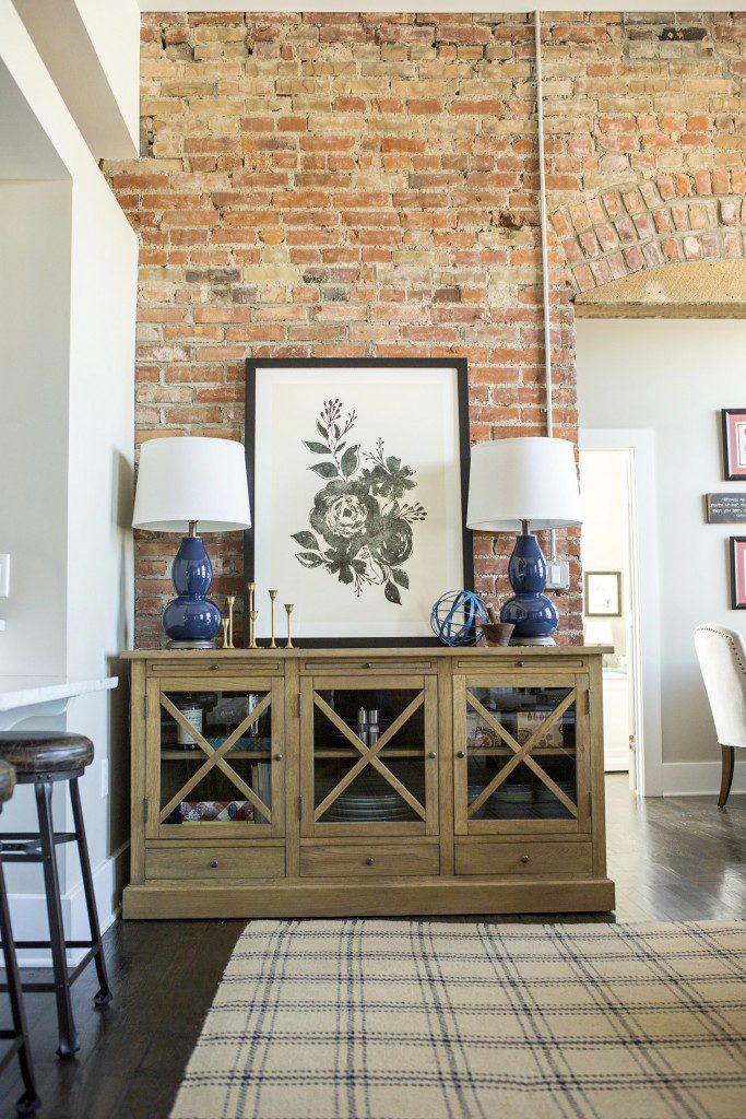 A living room with brick walls and a large painting