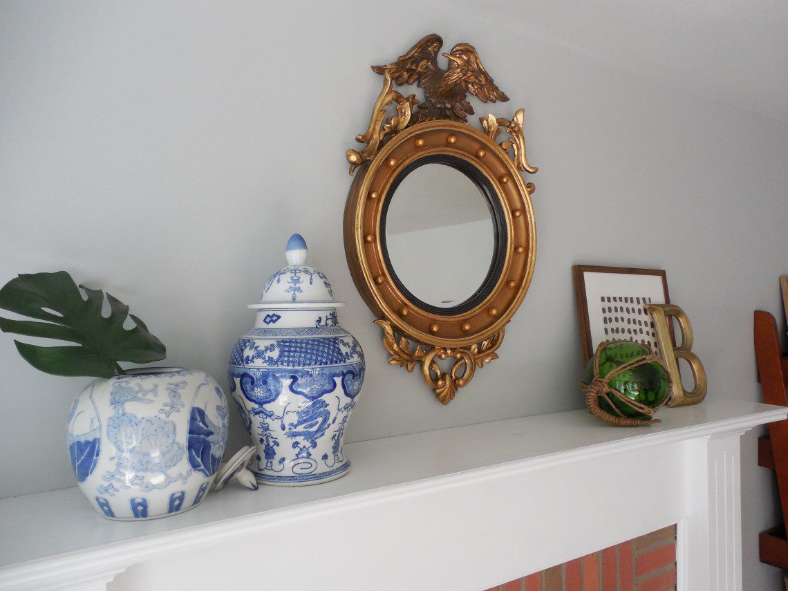 A mirror and some vases on top of a mantle.