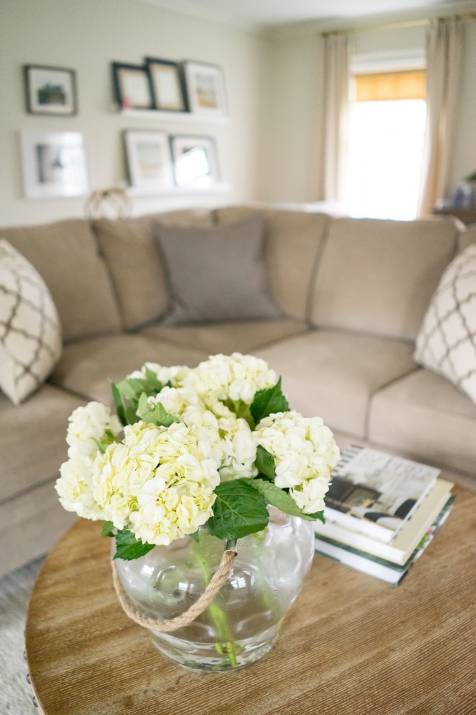 A living room with a couch and flowers in the vase