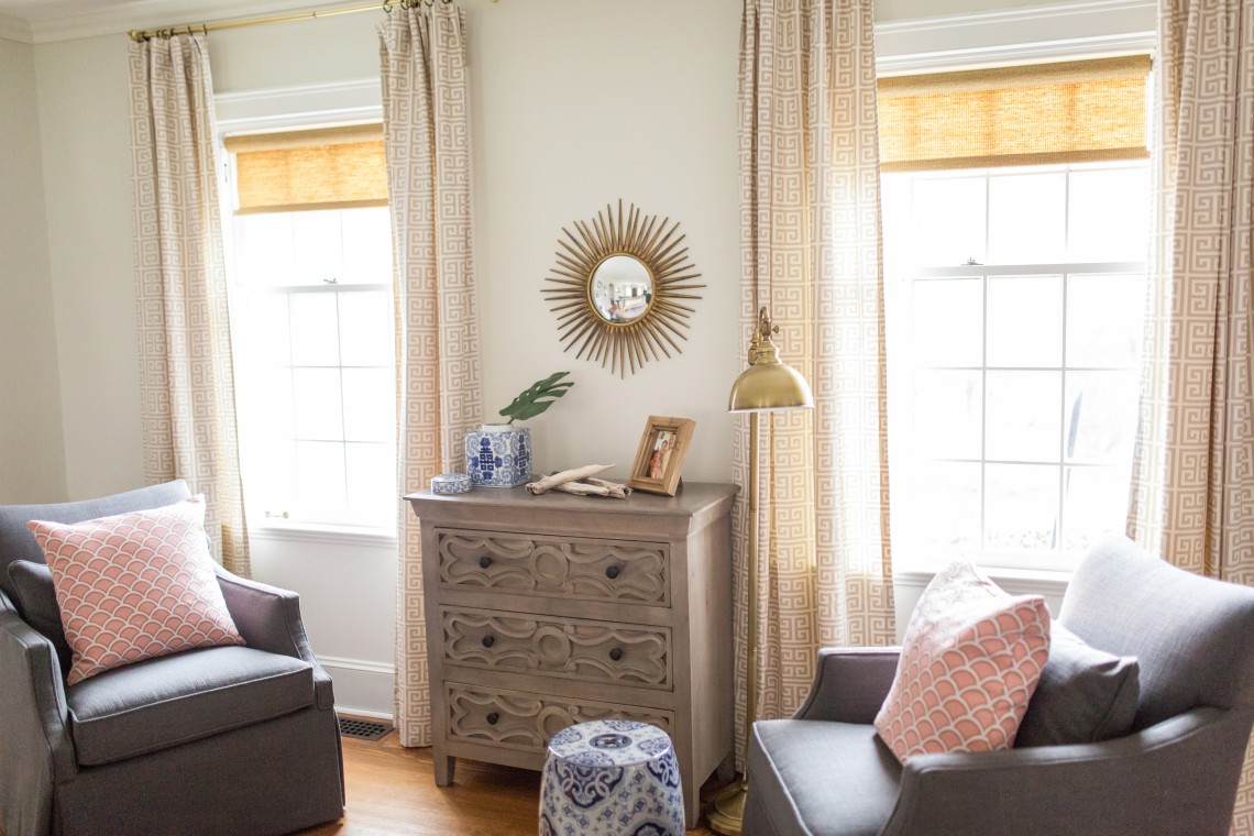 A living room with two windows and a dresser