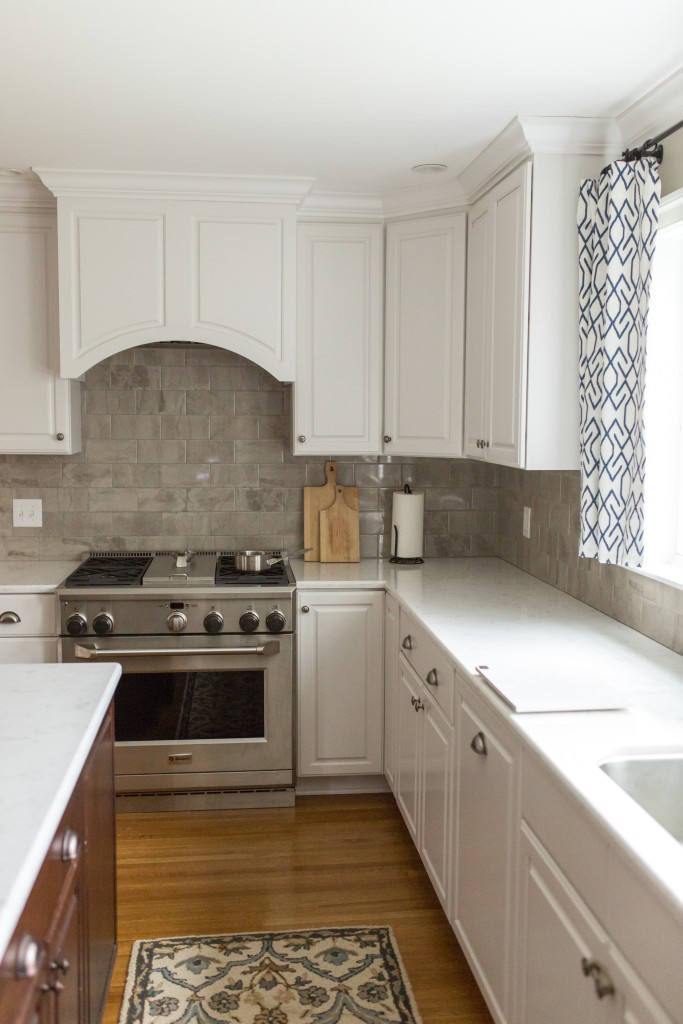 A kitchen with white cabinets and a stove.