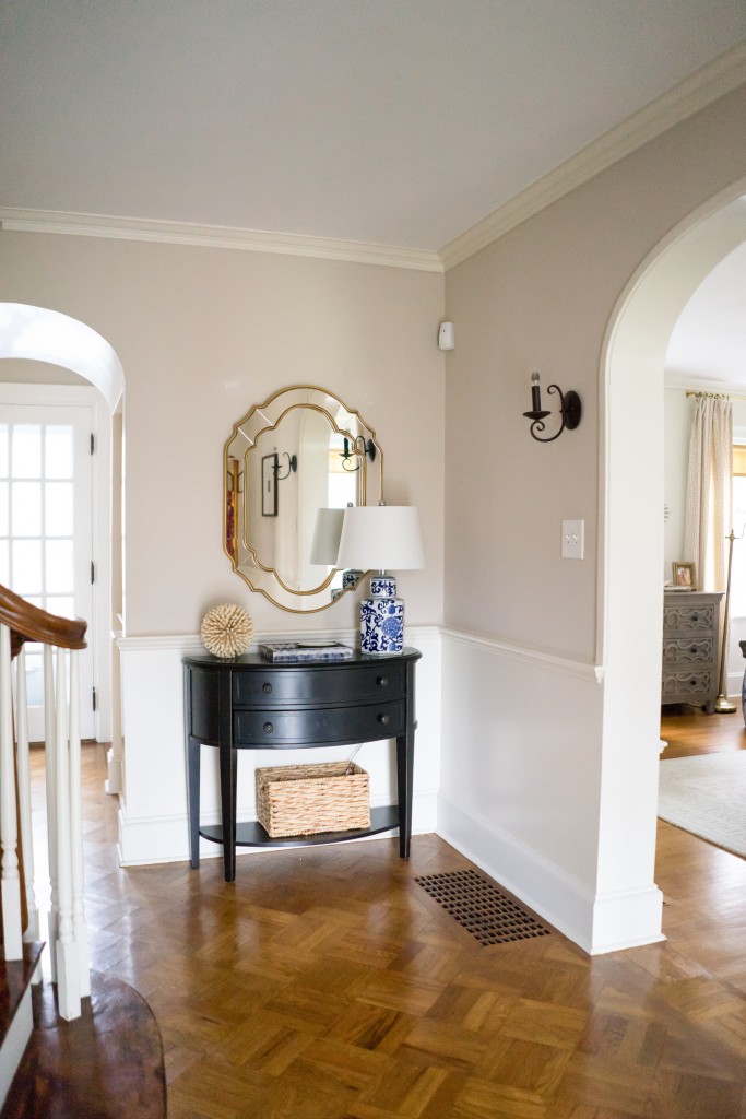 A foyer with a mirror and a table in it