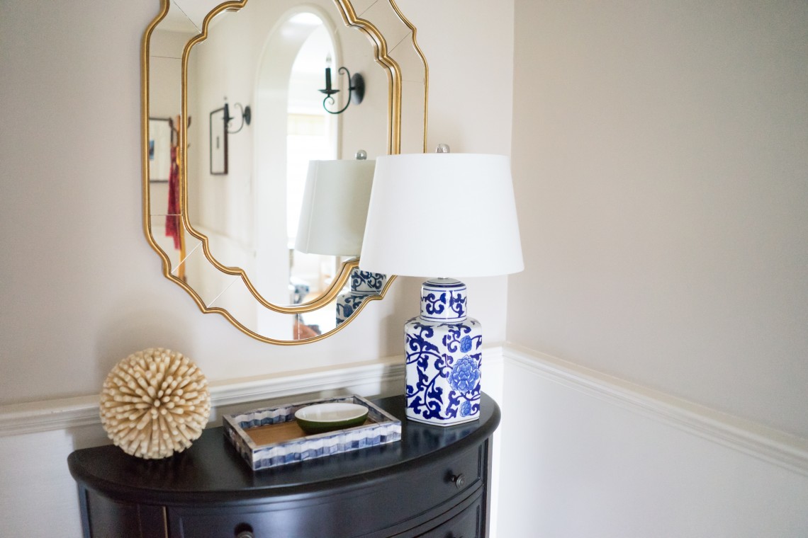 A lamp sitting on top of a table next to a mirror.