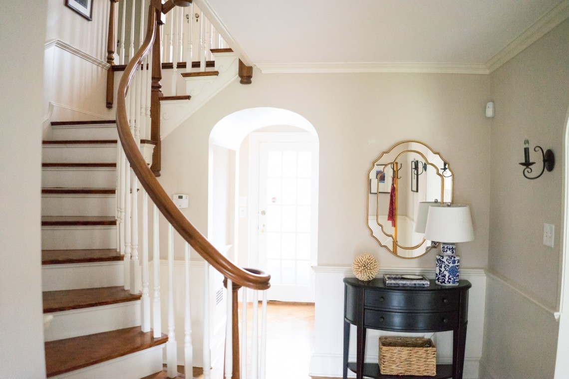 A foyer with a table and mirror in it