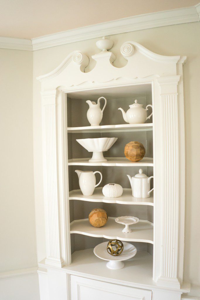 A white cabinet with many different types of dishes on it.