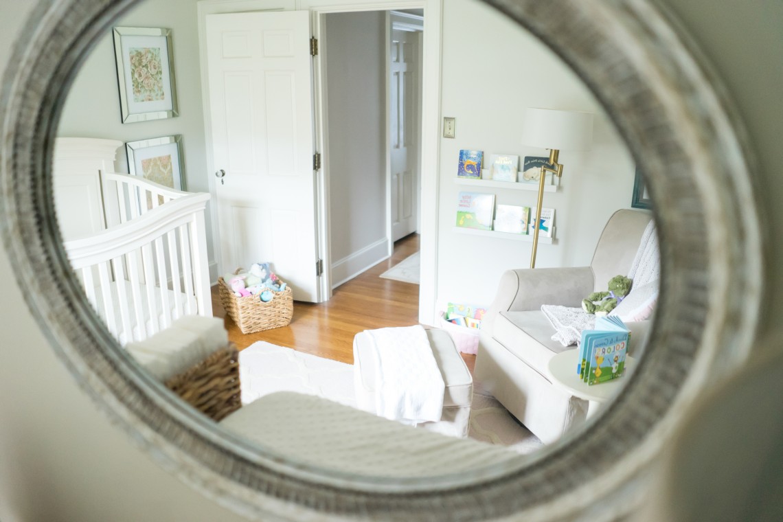 A view of the baby 's room through a mirror.