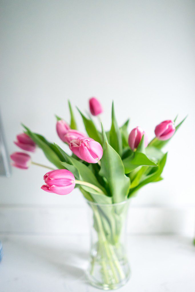 A vase filled with pink flowers on top of a table.