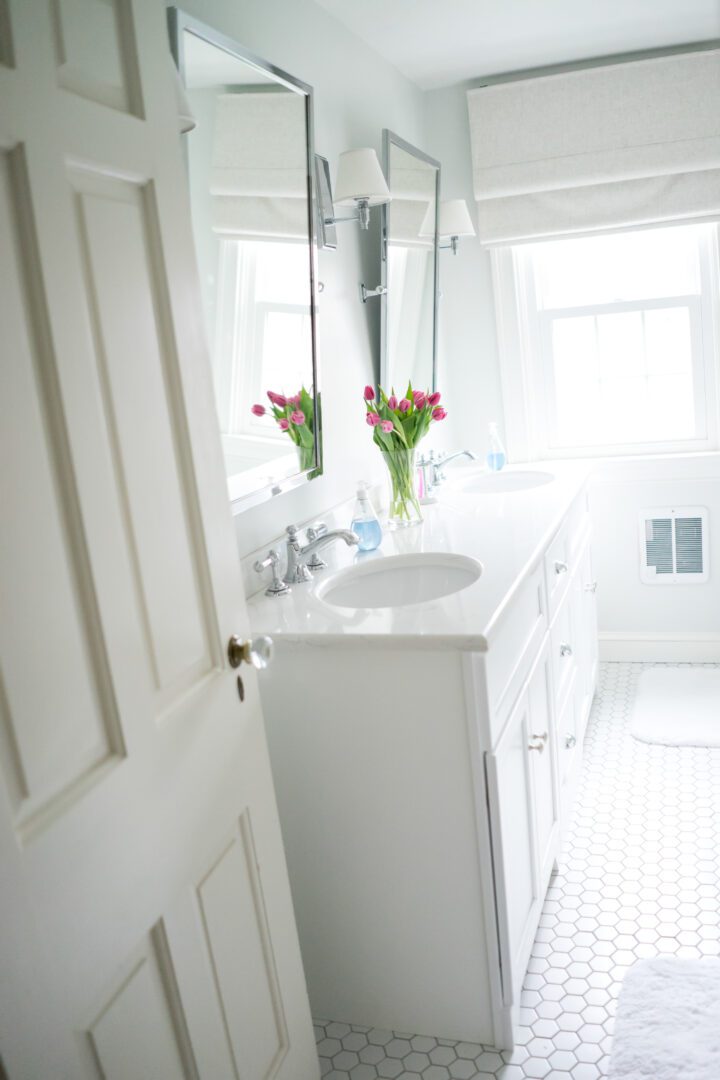 A bathroom with white cabinets and a sink.