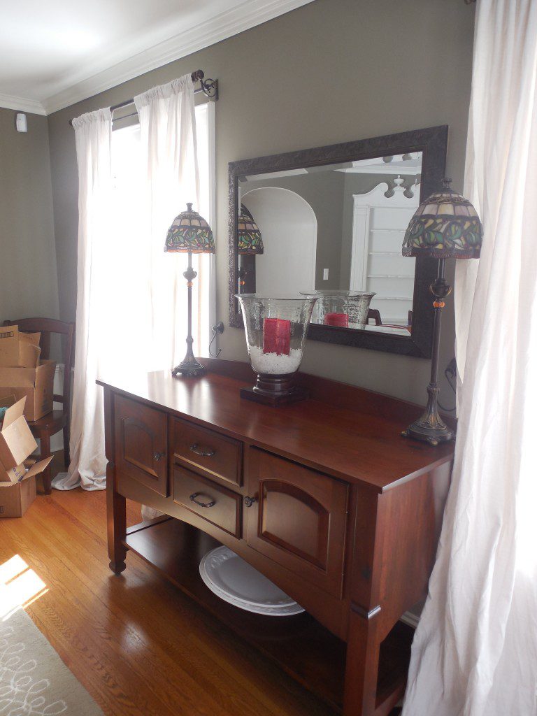 A wooden table with two lamps and a mirror