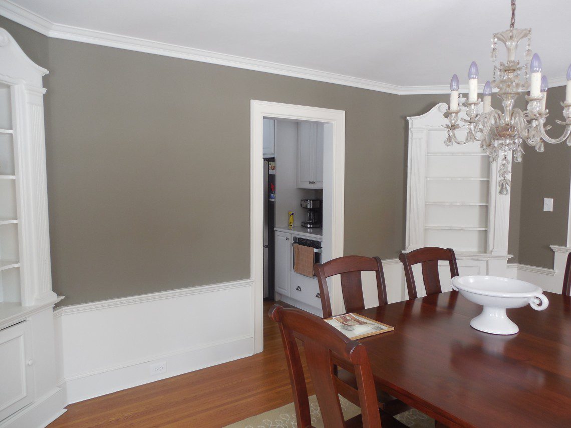 A dining room with a table and chairs, and a door open.