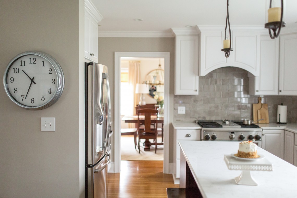 A kitchen with white cabinets and wooden floors