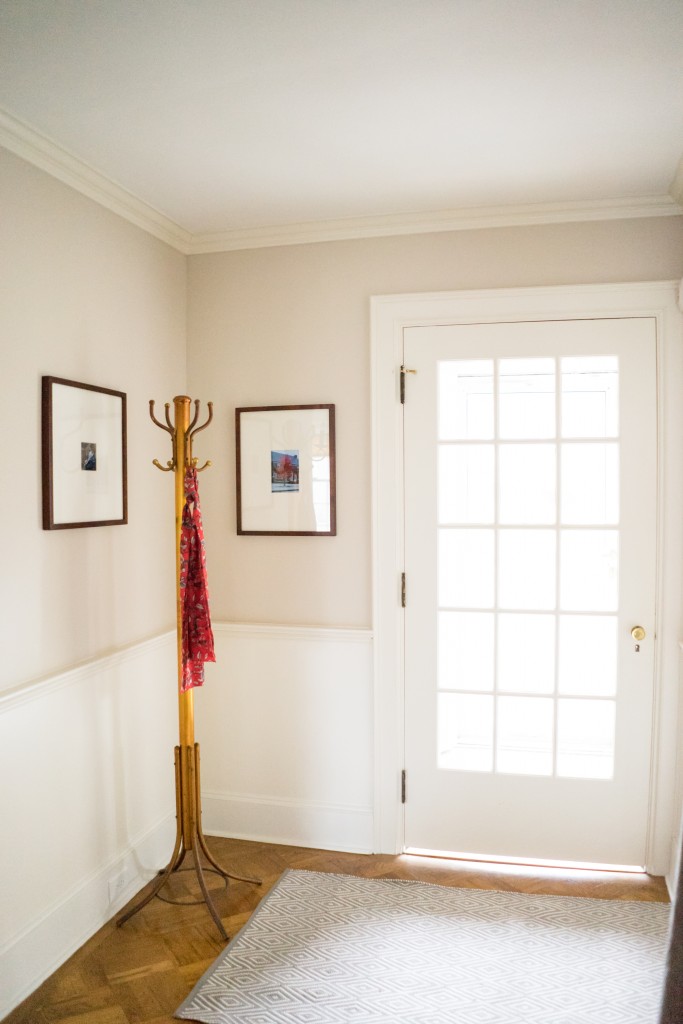 A white door with two framed pictures hanging on the wall.