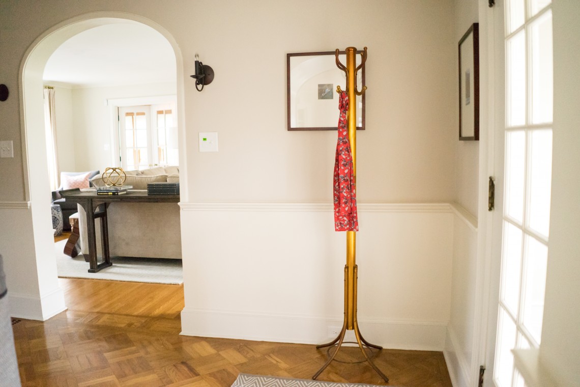 A coat rack with a scarf hanging on it.