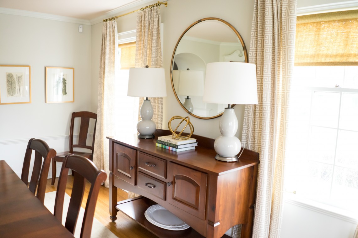 A dining room table with two lamps on it