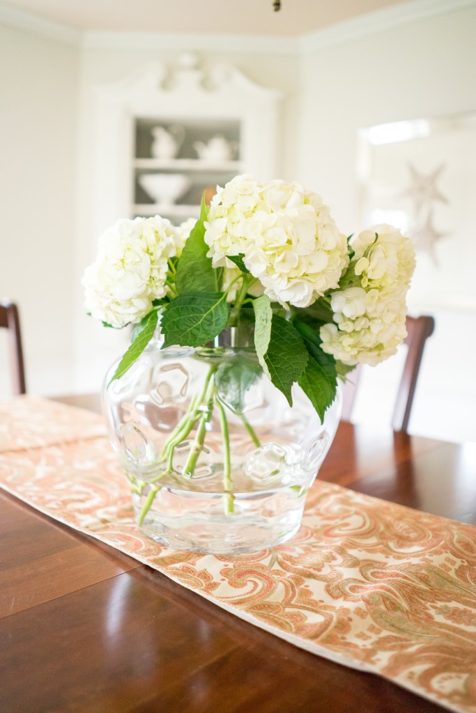 A vase with white flowers on top of the table.