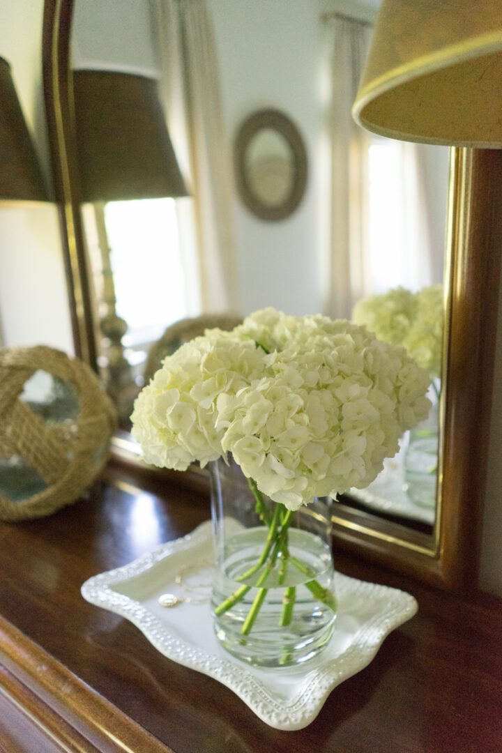 A vase of white flowers on top of a table.