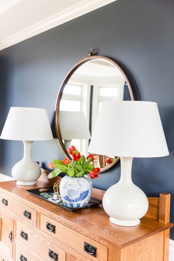 A dresser with two lamps and a mirror