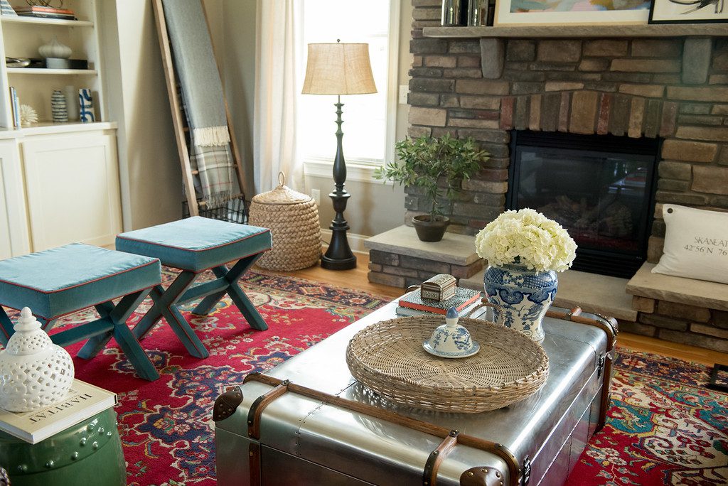 A living room with red rugs and blue accents.