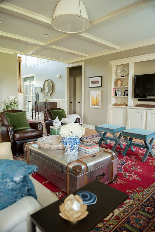 A living room with a red rug and blue chairs