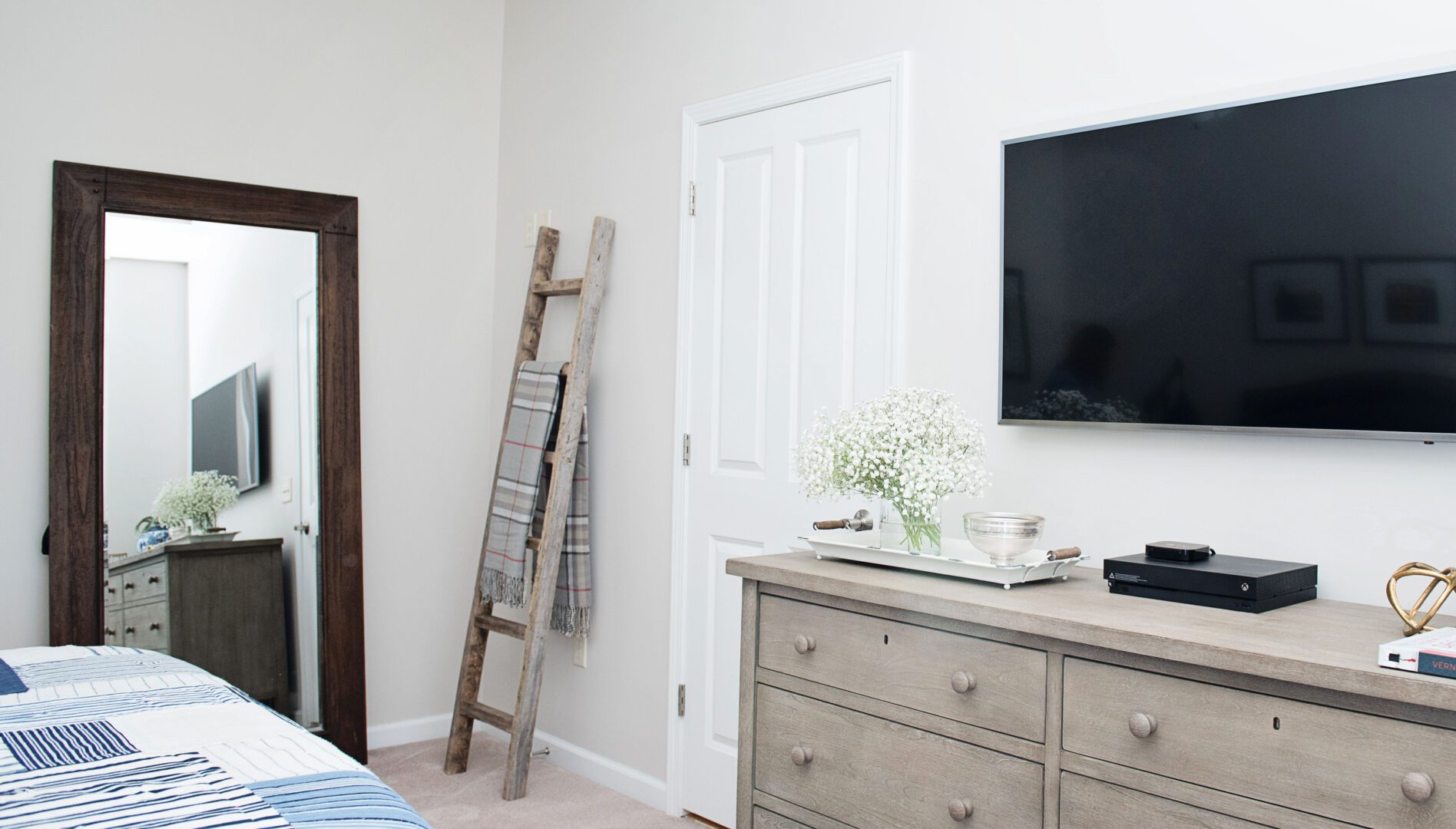 A bedroom with a tv and dresser in it