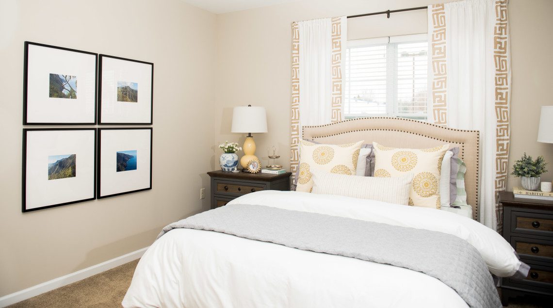 A bedroom with a bed, nightstand and two lamps.