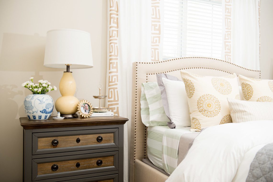 A bedroom with a dresser and nightstand in it