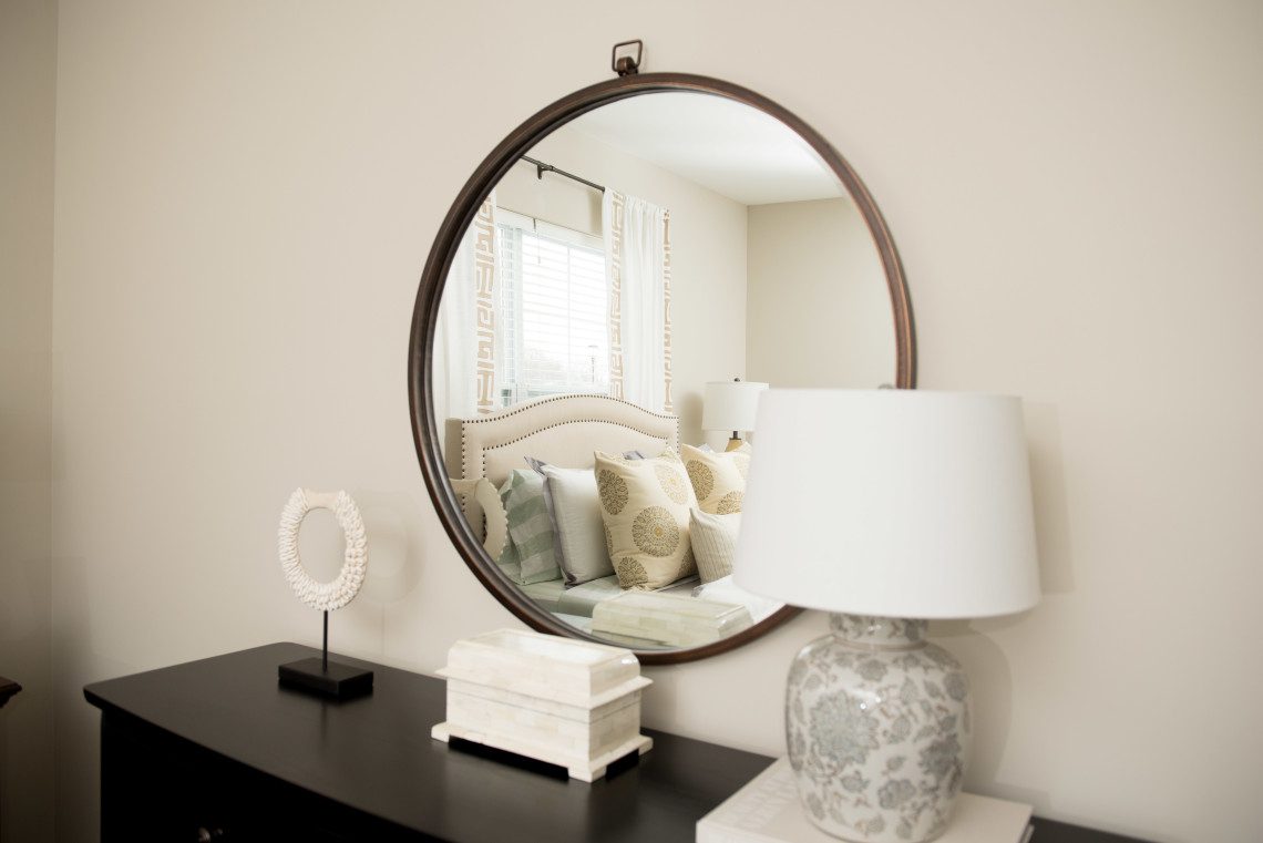 A mirror sitting on top of a dresser.