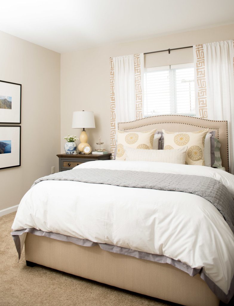 A bedroom with a bed, nightstand and window.