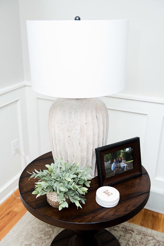 A white lamp sitting on top of a wooden table.