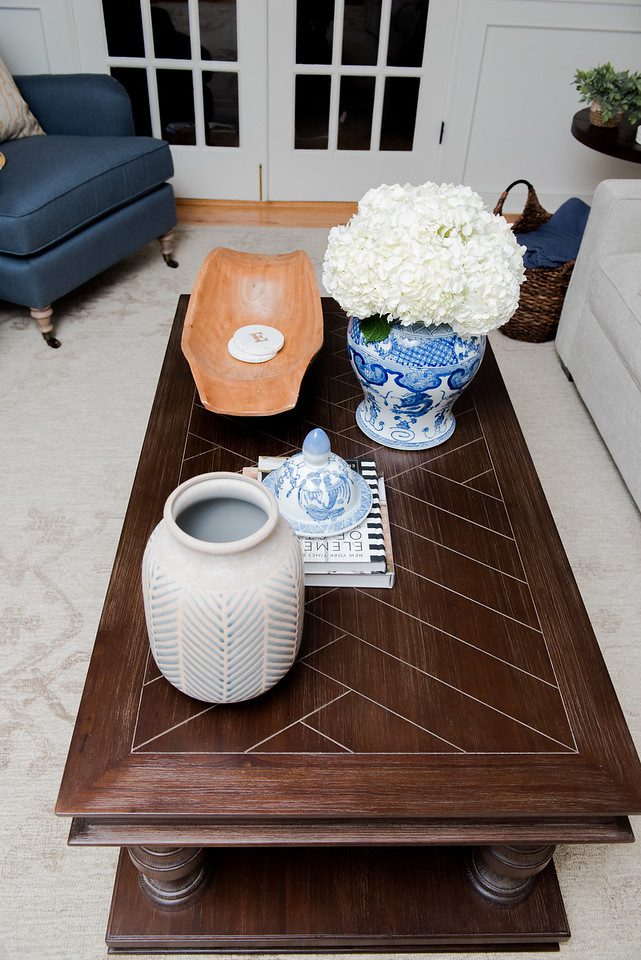 A coffee table with two vases and a book.